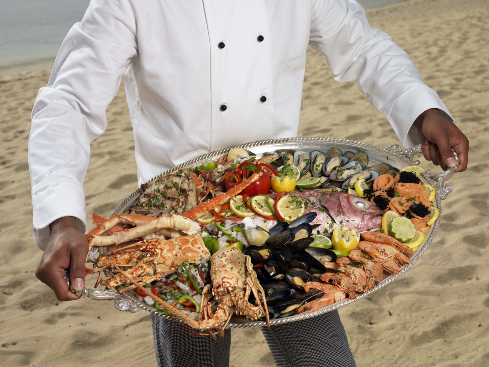 Chef holding a platter of fresh seafood